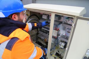 Elektriker vor Stromkasten verdrahtet den Schaltschrank