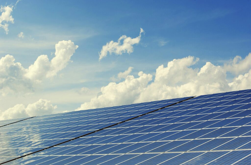 Solarmodule unter blauem Himmel mit Cumulus Wolken